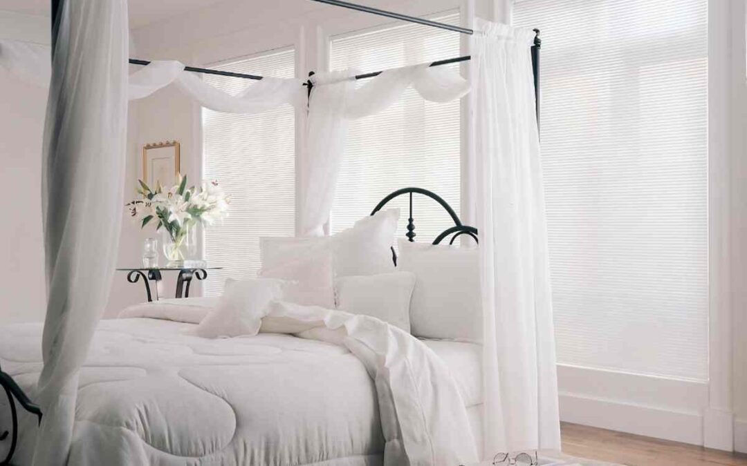 Sleek Hunter Douglas Modern Precious Metals® Mini Blinds on windows in a bedroom with white linens at Marksons Furniture & Windows near Grand Cayman Islands